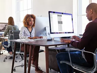 Three office workers working at desks