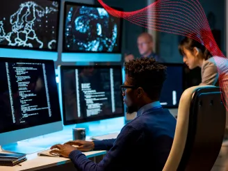 Man reviewing data on multiple PC screens